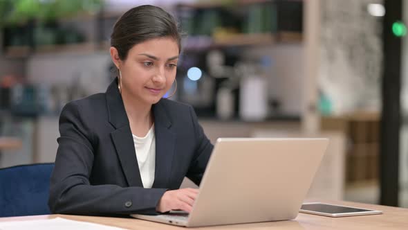 Indian Businesswoman with Laptop Smiling at Camera in Cafe 