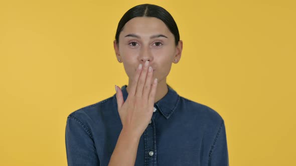 Latin Woman Giving Flying Kiss, Yellow Background 