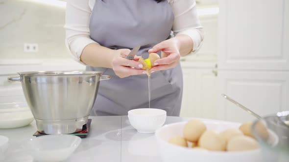 A Woman Breaks an Egg and Separates Yolks From Proteins