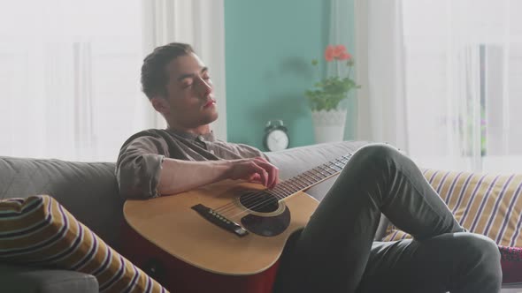 Young Man Enjoys Playing Guitar