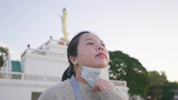 Close up of Asian woman standing and taking deep  breath at park