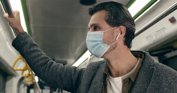 Close Up of Handsome Man in Protective Medical Mask Using Smartphone