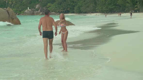 Beautiful Happy Couple Resting on the Beach on Island