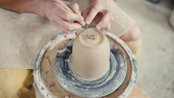 Close Up of Potter Artist Sculpting on Pottery Wheel Working with Pot Tracking Shot Slow Motion