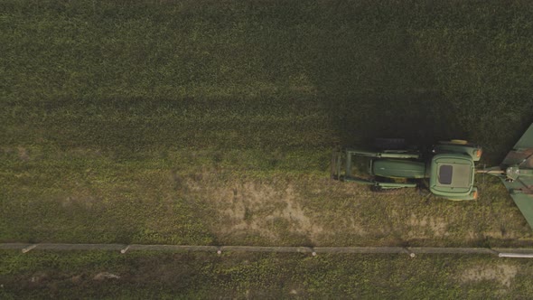 Top view of a green tractor moving along a field