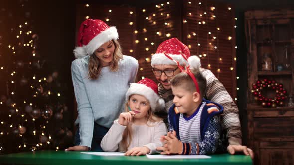 Parents and Children Writing Letter Wish List to Santa Claus