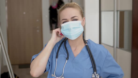 Female Doctor Tired After Long Shift Taking Off Her Medical Face Mask with Huge Relief