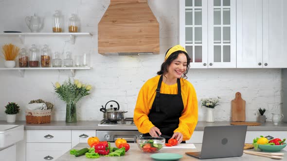 Laughing Woman in Home Kitchen Slices Tomato Listen Chef Study Online Laptop