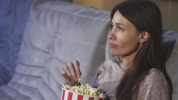 Close Up of a Mature Woman Eating Popcorn Smiling at the Cinema