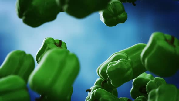 Slow motion animation of natural green bell peppers falling down. Loopable. HD