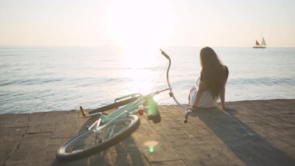 Young Attractive Woman with Long Hair is Having a Good Time on Sea at Sunset or Sunrise