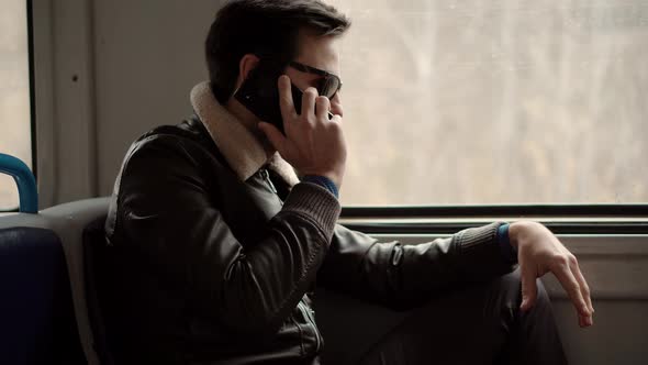 Man In Sunglasses Using Mobile Phone And Call To Friends. Man Talking On Smartphone In Train.