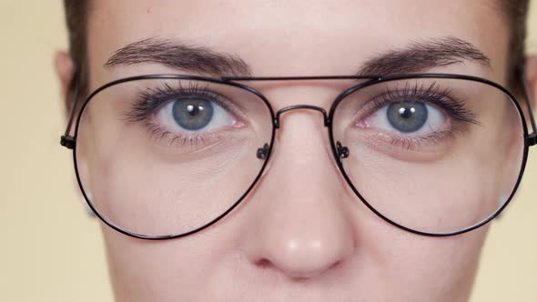 Close Up Face of Young Woman with Glasses, Looking at Camera, Blinking