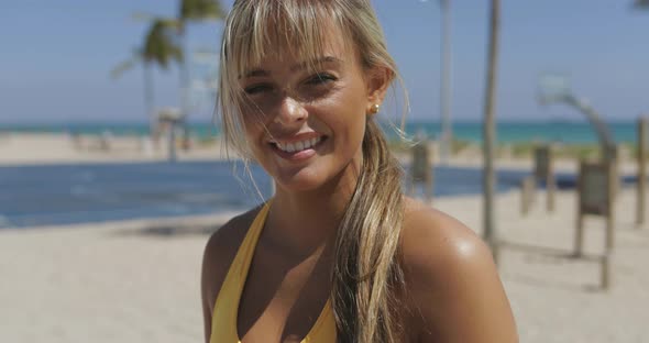 Charming Blond Girl on Beach in Sportswear