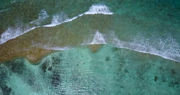 Natural flying travel shot of a sunshine white sandy paradise beach and aqua blue water background i