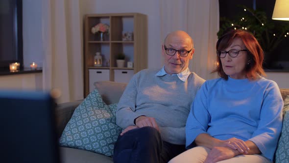 Happy Senior Couple Watching Tv at Home in Evening