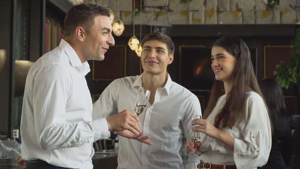 Group of corporate people drinking champagne and discussing at the company party