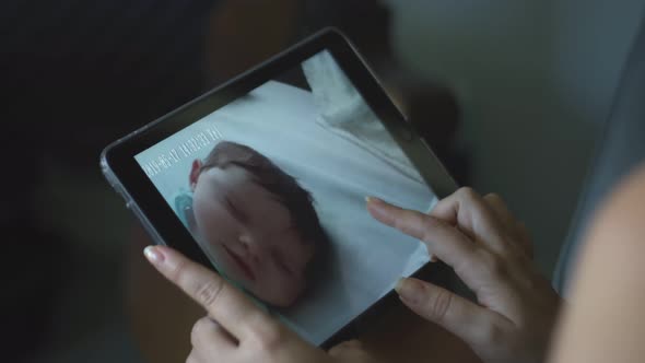 Slow Motion of Woman Looking at Her Baby on Tablet and Kissing It