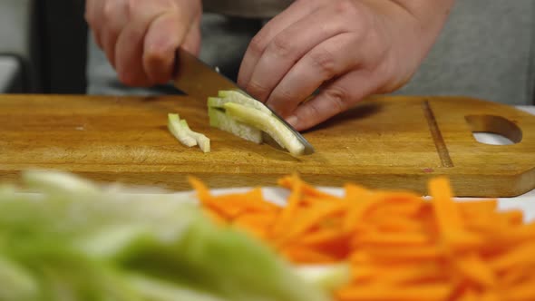 In Slow Motion the Cook Slices a Green Radish Into Straws