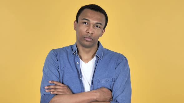 Young African Man Looking at Camera, Yellow Background