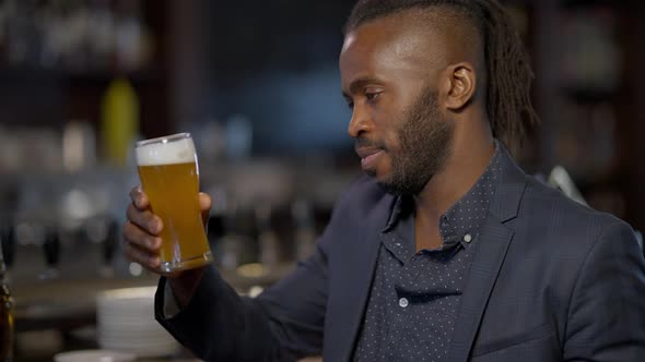 Handsome Cheerful African American Man Raising Beer Glass Winking Smiling Looking at Camera