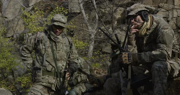 Soldiers Taking a Break and Checking a Handgun alt