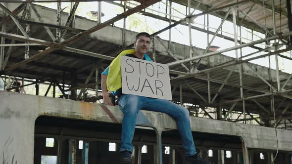 Man with Ukrainian Flag Holding Banner Stop War