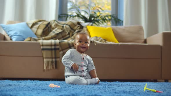 Cute Little Afro Baby Girl Sitting on Blue Carpet in Living Room Home Alone