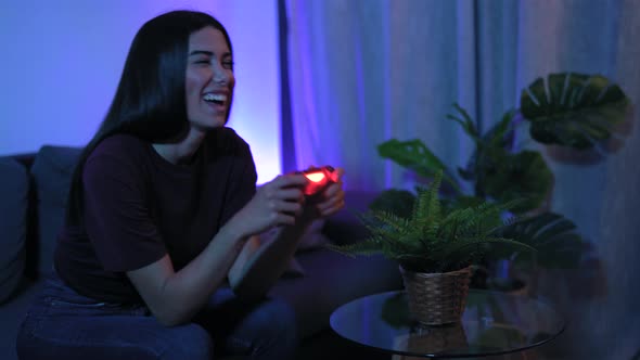 Young woman playing online video games at home