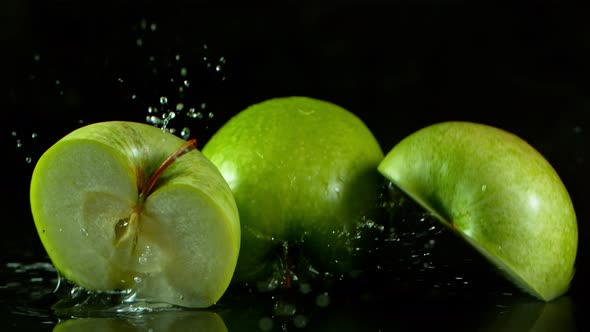 Super Slow Motion Shot of Fresh Green Apples Falling Into Water Isolated on Black at 1000Fps