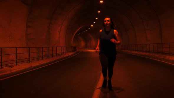 Female runner in tunnel.