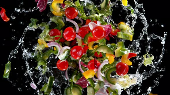 Super Slow Motion Shot of Rotating Exploded Salad and Splashing Water on Black at 1000Fps