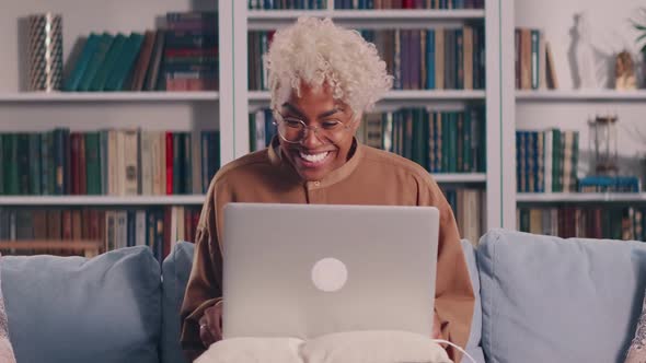 African Woman Looking at Laptop Screen Reading Email with Unbelievable Win News