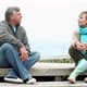 Couple sitting on coastal walkway, talking and holding hands - VideoHive Item for Sale
