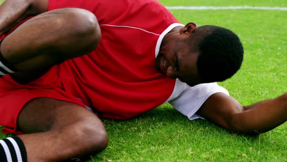 Injured football player lying on grass