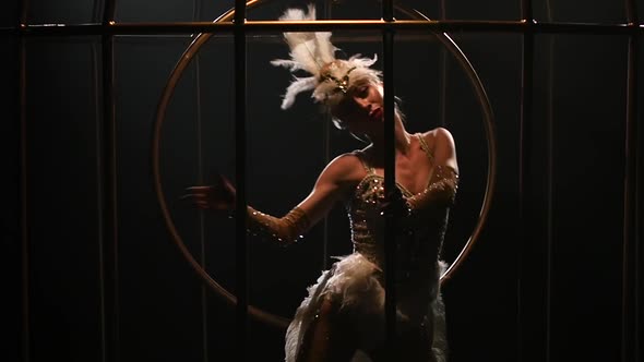 Gymnast a Spinning on a Hoop in a Gold Cage