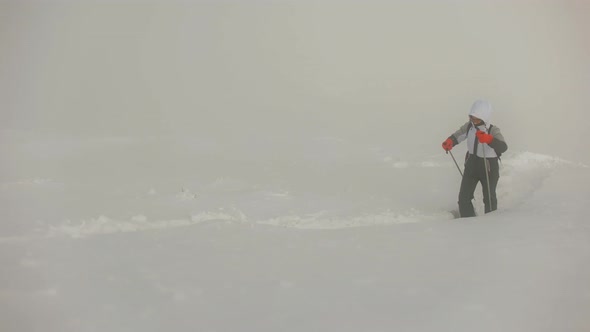 A Young Woman is Walking Through Deep Snow