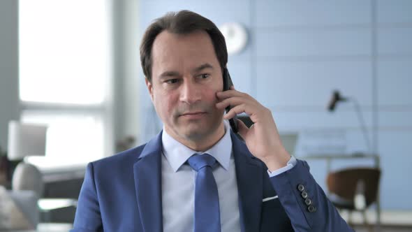 Businessman Negotiating with Customer During Phone Talk