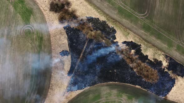 Top Aerial view of Smoking wild fire in Africa. Flying above  Wildfires. Dry Grass burning