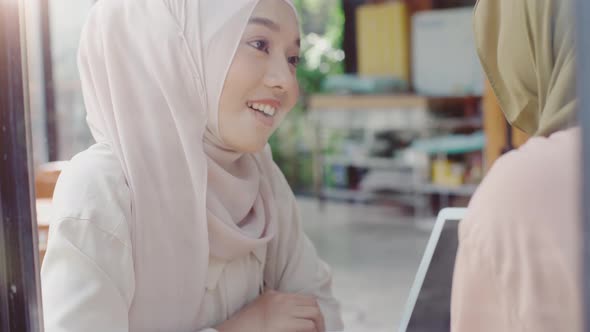 Young Asian Muslim Women Enjoying A Relaxing Moment in the Coffeeshop