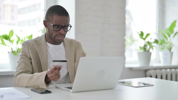 African Man Making Online Payment Failure on Laptop in Office