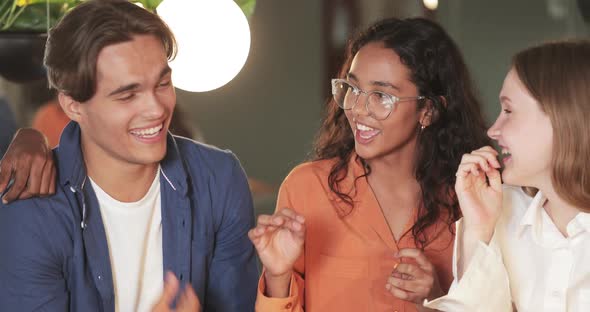 Close Up View of Young Good Looking Friends Laughing and Having Fun in Cafe. Multiethnic Millennial