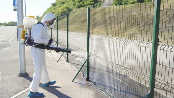 Young Sanitation Worker in Hazmat with Pressure Washer Outdoors