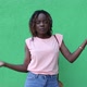 African-American woman listens to music with headphones and dances, on a green background - VideoHive Item for Sale