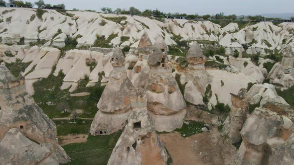 Aerial backward moving shot of rocky landscape with unusual rock formation called fairy chimneys in