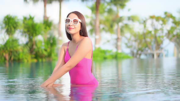 Young asian woman enjoy around outdoor swimming pool for leisure