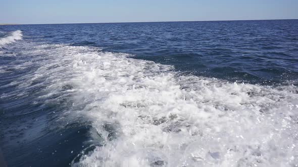 Motor Boat Goes Fast on the Sea and Creates Large Splashes Waves Above the Surface of the Water