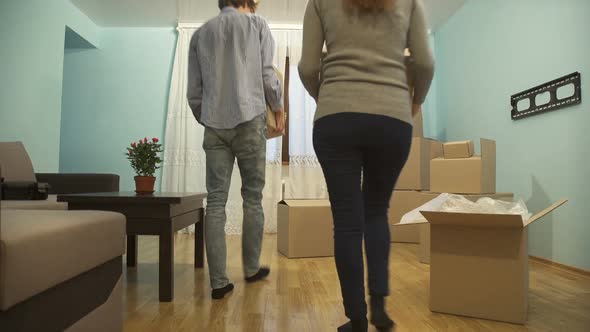 Young Couple Collects Things in a Box for Moving To a New Apartment