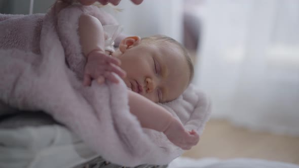 Carefree Newborn Baby Sleeping in Basket with Woman Kissing Hand and Cheek in Slow Motion