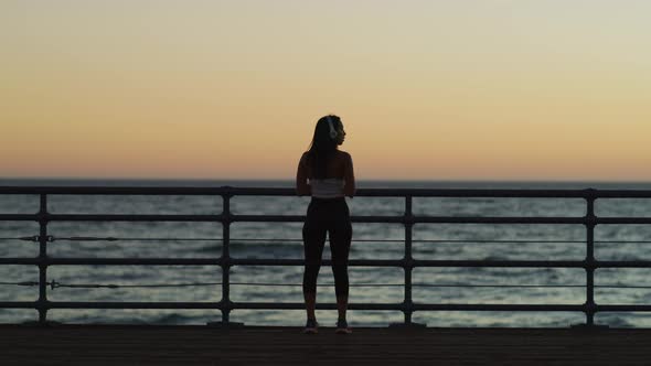 Athletic girl standing on a pier